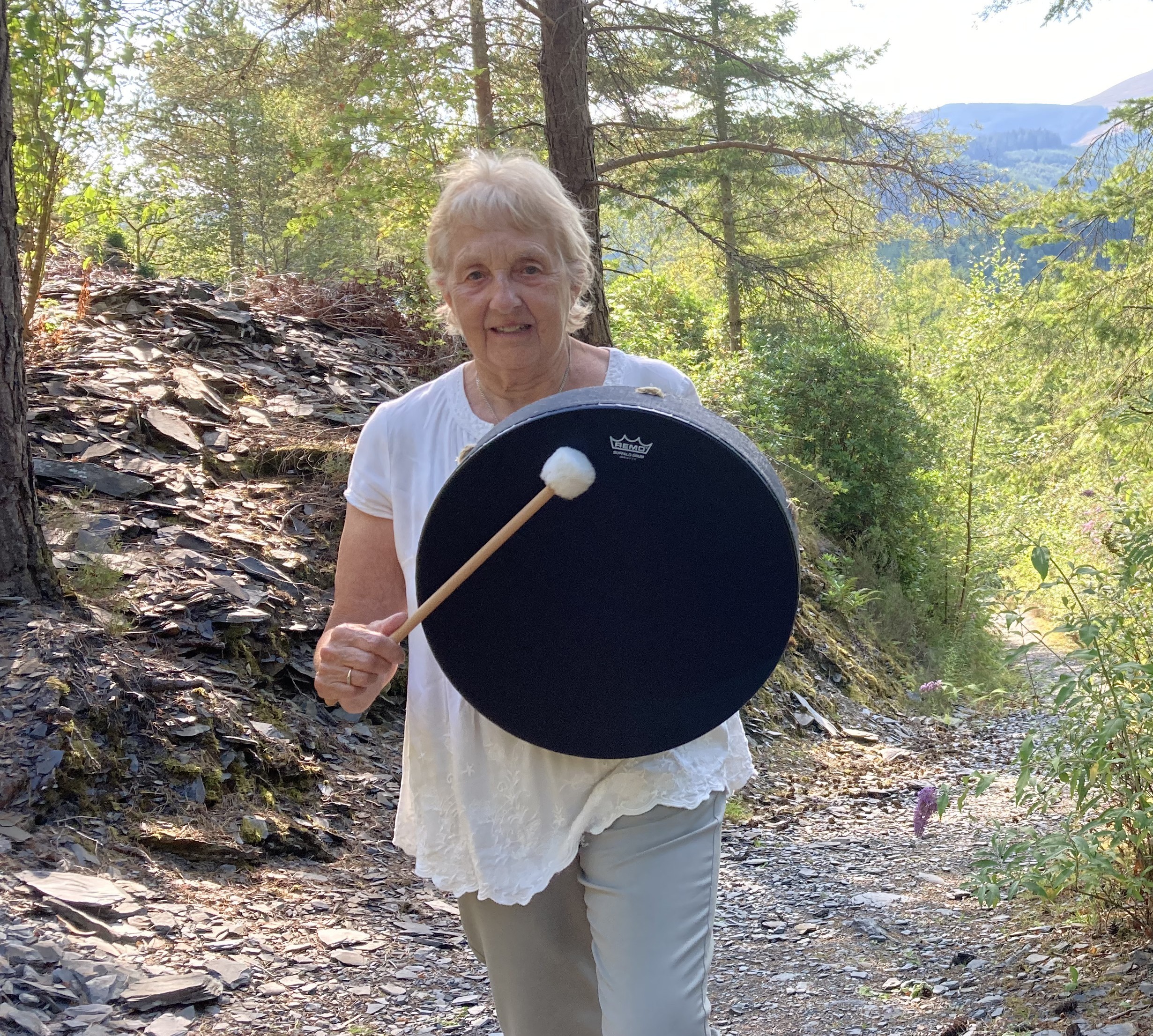 Maggie in nature holding a drum